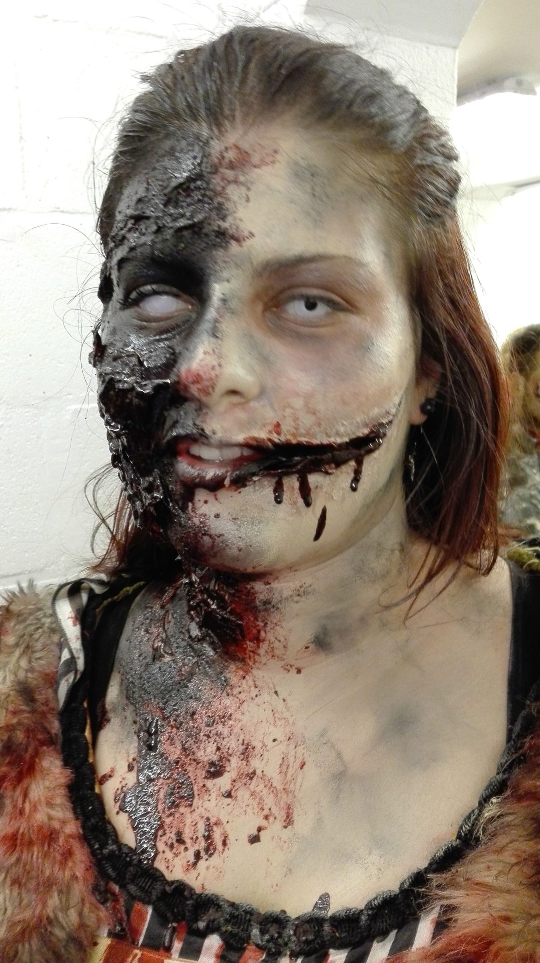 Maquillage de zombie pour Halloween, visage arraché et sourire de l'ange